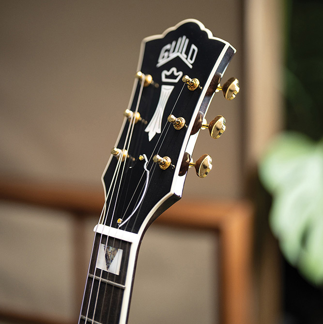 Close-up of the headstock on a Starfire Custom DC GVT GH, showing the Guild Peak and Chesterfield inlays and Grover open-gear tuners.