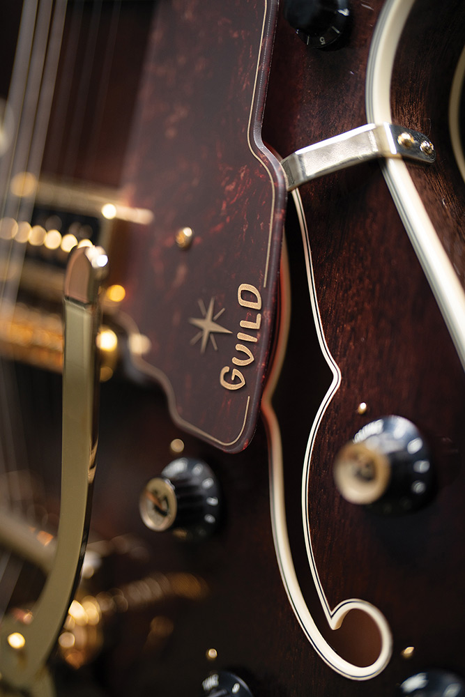 Close-up of the lower bout on a Starfire Custom DC GVT GH, showing the Guild starburst logo, vibrato arm, and control knob.