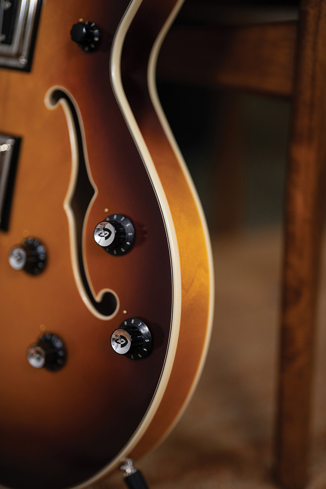 Close-up of the lower body bout on a Starfire Deluxe Bass Sweet Tea, showing the F-hole, and control knobs.