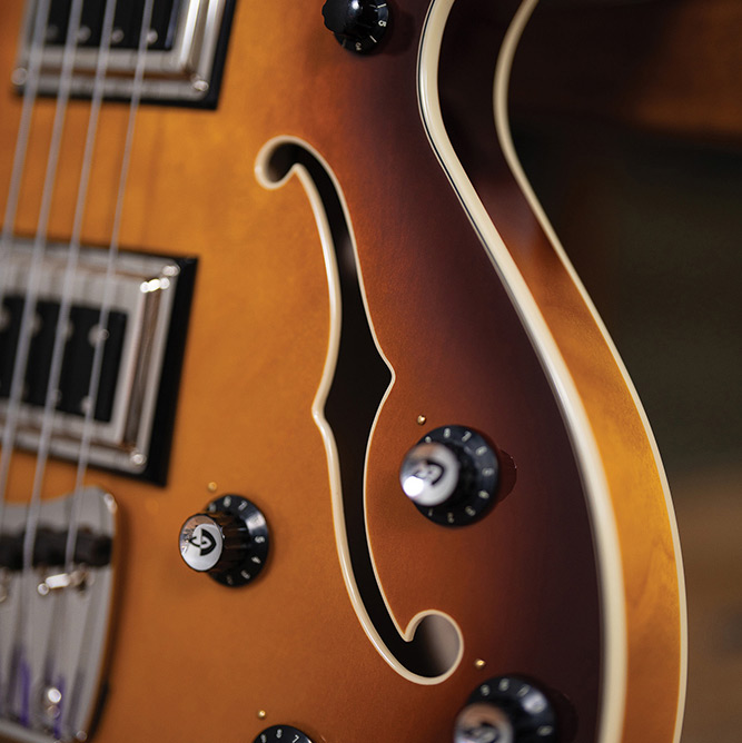 Close-up of the Starfire Deluxe Bass Sweet Tea showing the F-hole, control knobs, and ivory binding.