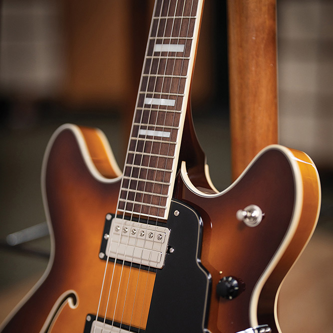 Close-up of the fingerboard and a pickup on a Starfire Deluxe DC Sweet Tea, showing the pearloid block inlays and ivory binding.