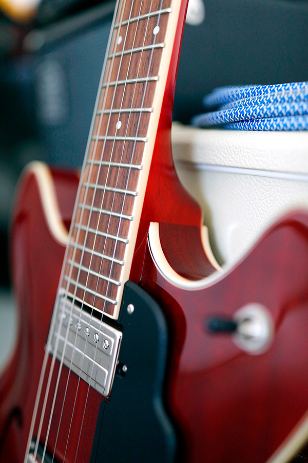 Thumbnail view of Starfire I DC Cherry red guitar leaning against an amp close up of neck