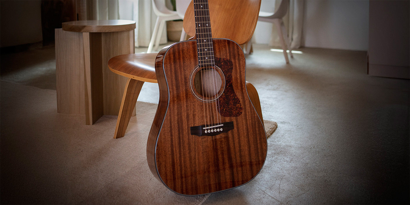 D-120 leaning against a wood chair in a cozy room