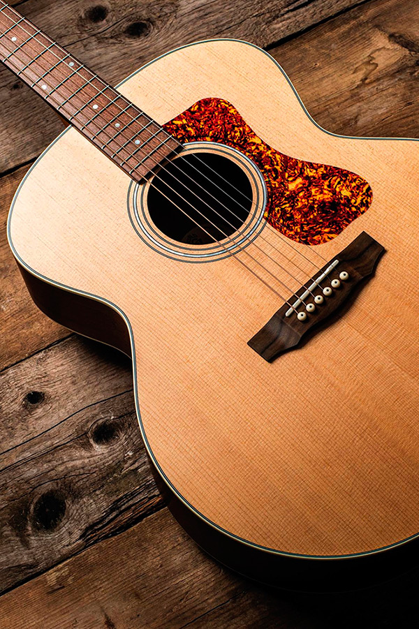 Close-up of F-240E Natural body showing pickguard, soundhole, and bridge