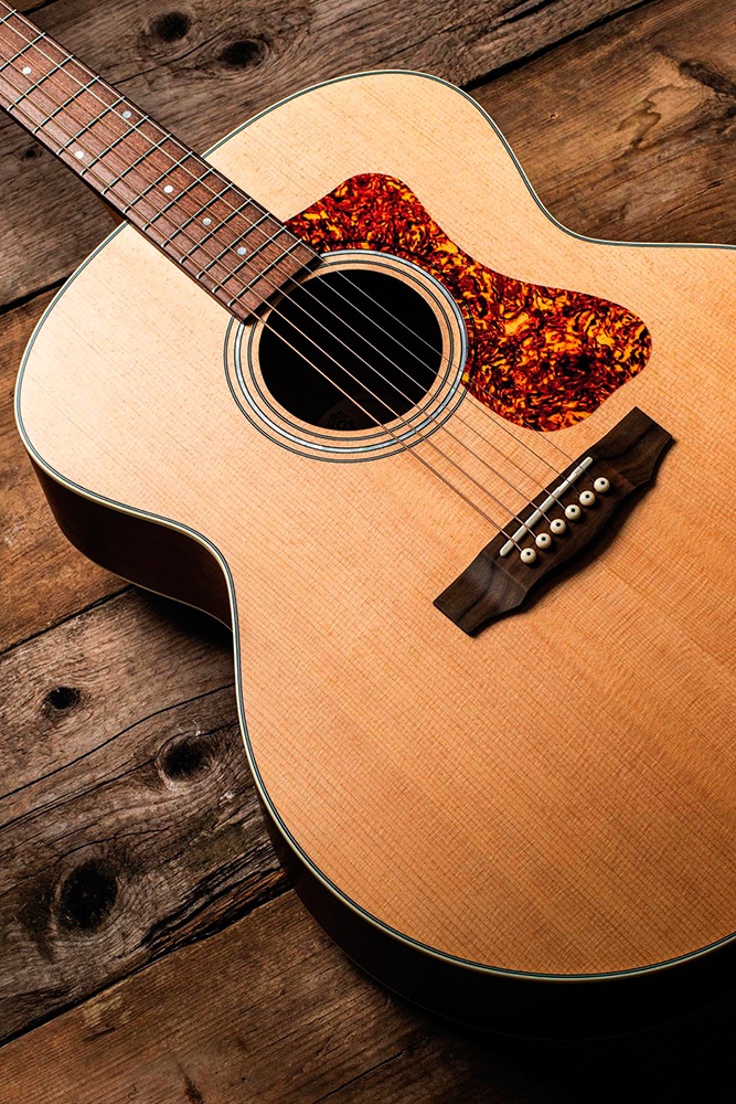 Close-up of F-240E Natural body showing pickguard, soundhole, and bridge