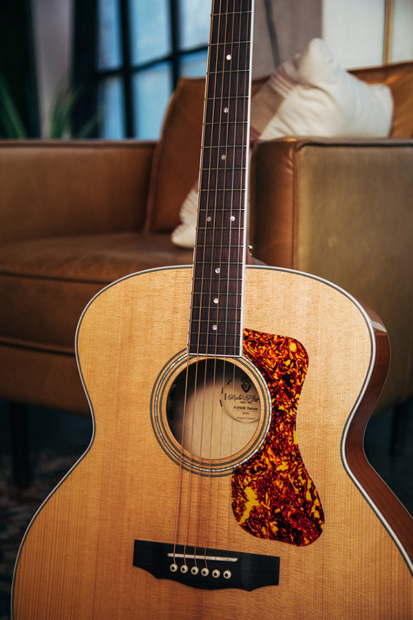 Close-up F-250E Deluxe Archback Blonde body showing soundhole, pickguard, and bridge
