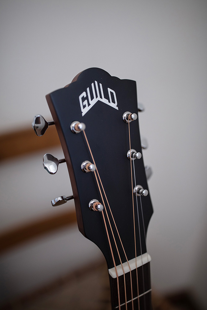 Close-up of OM-240E Natural headstock with Guild logo