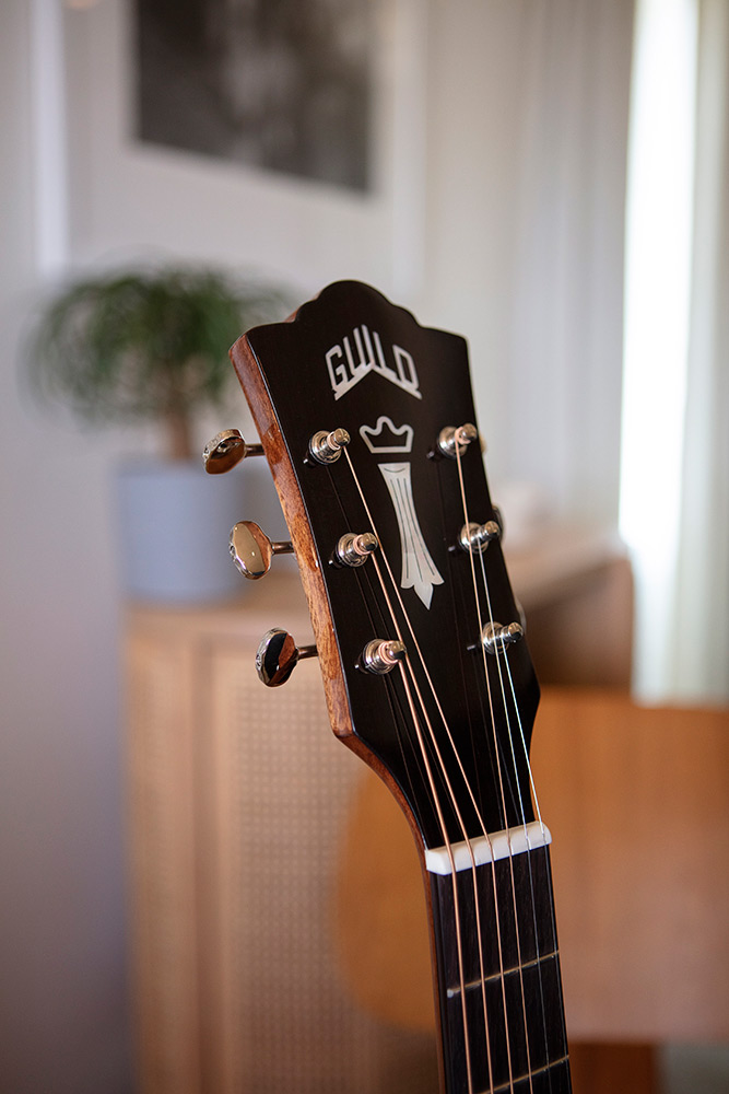 Close up of OM-120 headstock featuring Guild Peak Logo