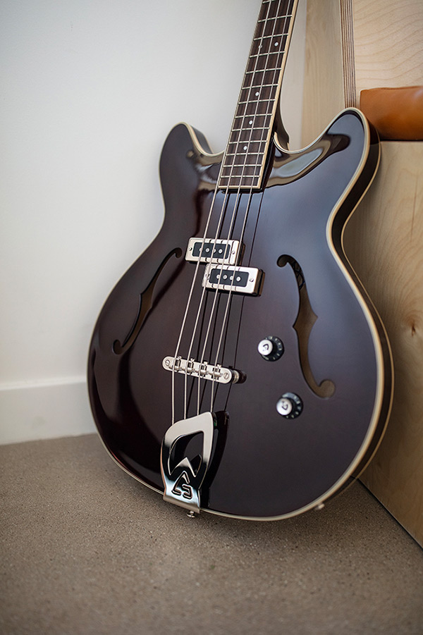 Starfire I Vintage Walnut bass body leaning against a wood bench thumb