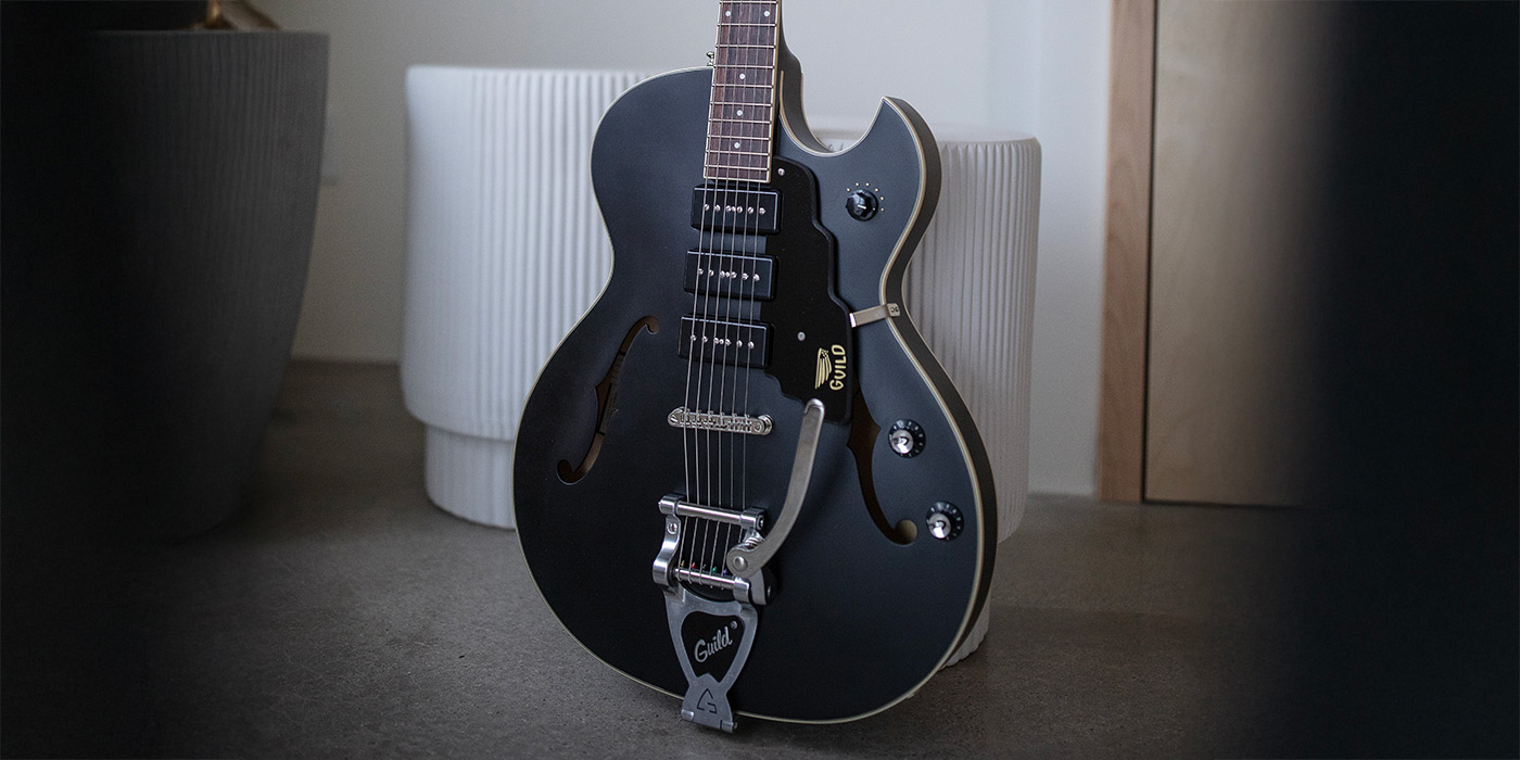 Starfire I Jet90 Satin Black leaning against pair of small round white coffee tables