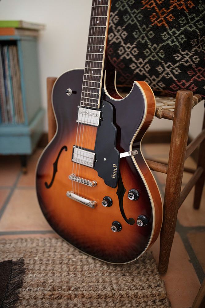 Starfire I SC Antique Burst leaning against a wood chair by a record cabinet