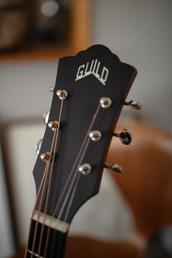 Close up of BT-240E Baritone Natural headstock showing Guild logo