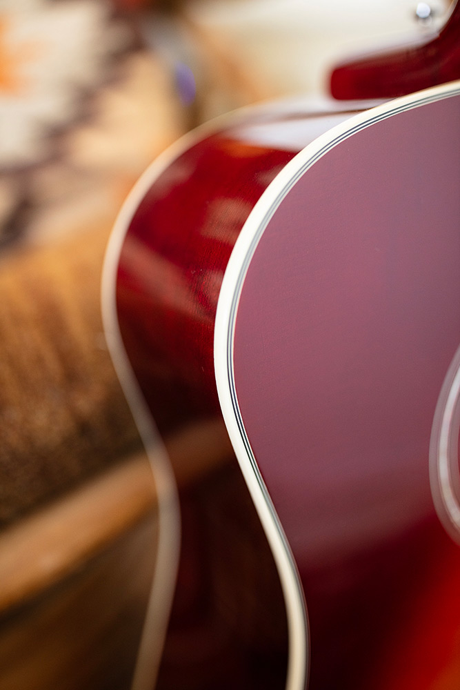 Close up of D-140 Cherry Burst body curve showcasing Solid Sitka Spruce top