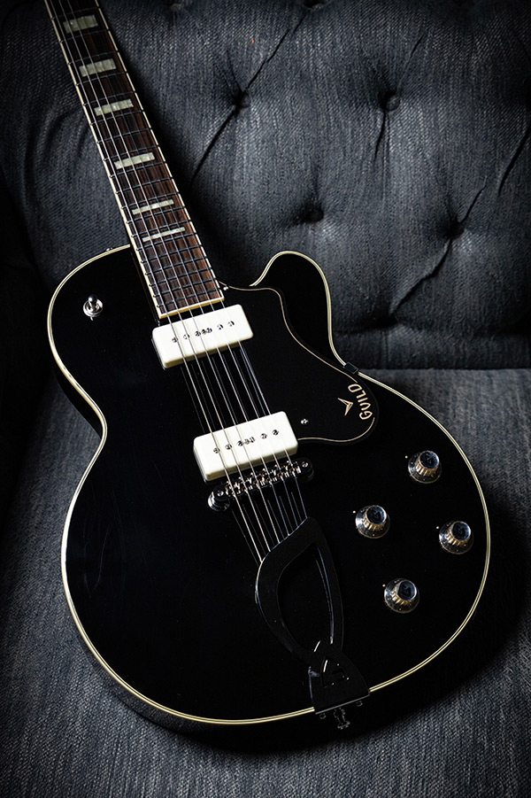 M-75 Aristocrat Black laying on a gray couch