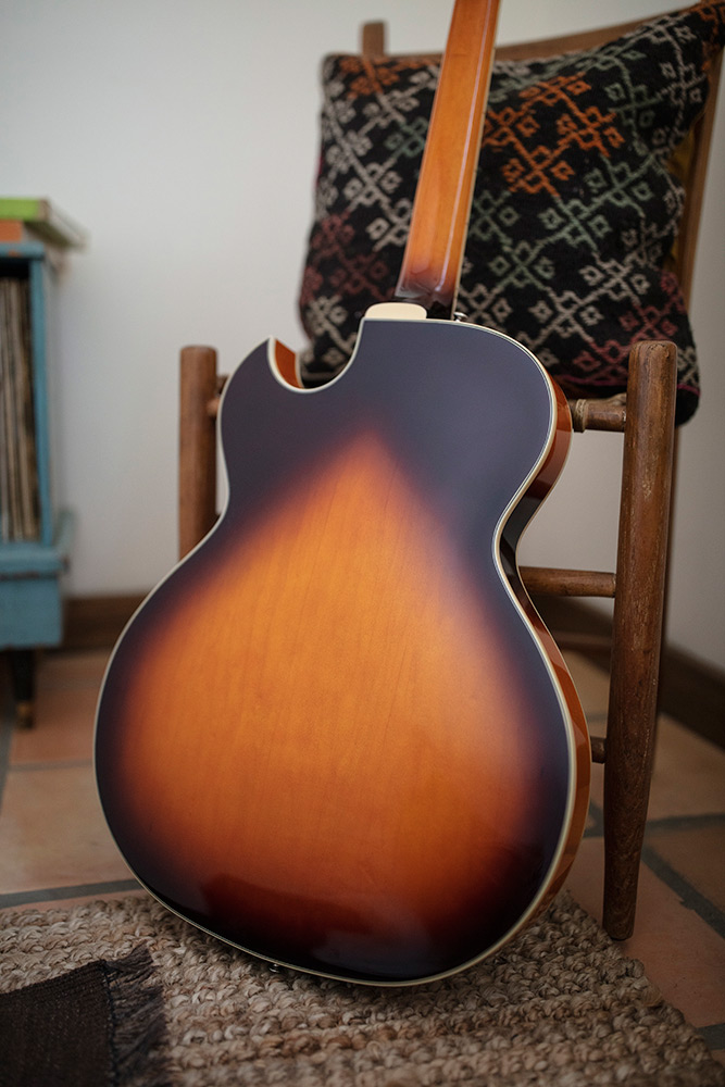 Starfire I SC Antique Burst leaning backwards against a wood chair in a cozy room