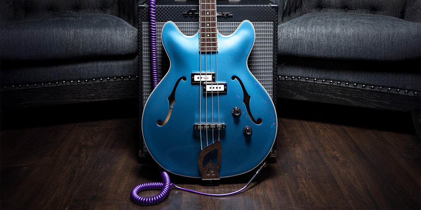 Starfire I Pelham Blue bass leaning against an amp inbetween two cushioned chairs