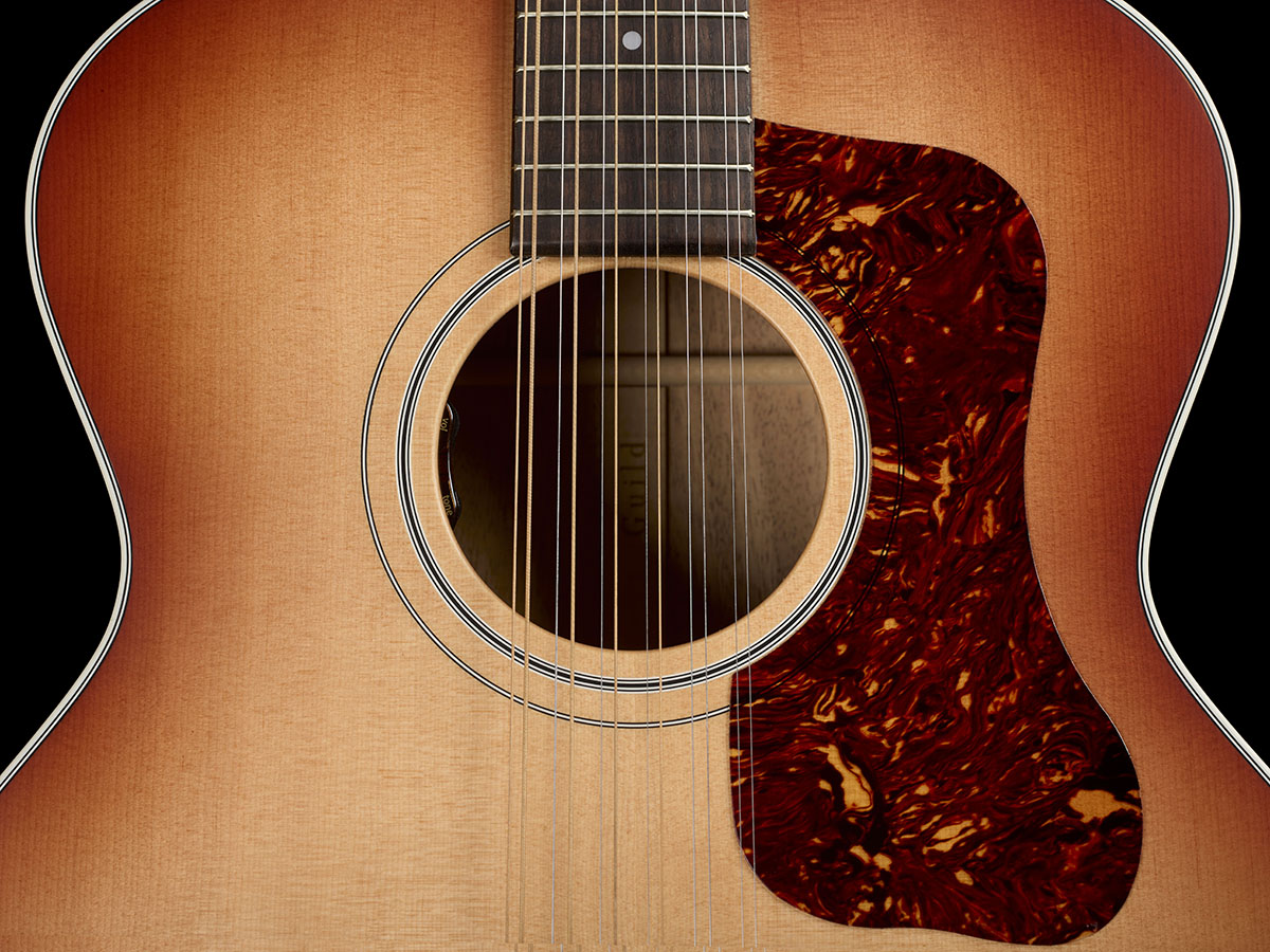Close-up of The F-412E Standard Pacific Sunset Burst body showing the soundhole and pickguard