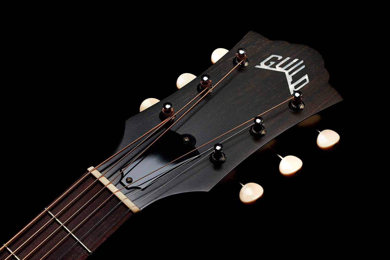 Close-up of front of the M-40 Standard Natural headstock with Guild Peak logo