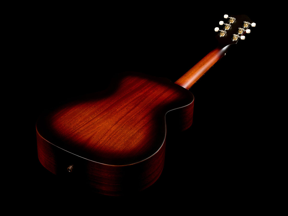 Angled back view of M-20 Vintage Sunburst acoustic guitar showcasing solid African mahogany back