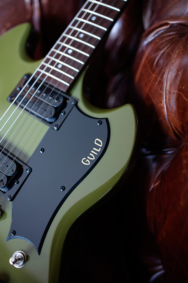 Close up of Polara Phantom Green pickguard with guitar laying on leather chair thumbnail