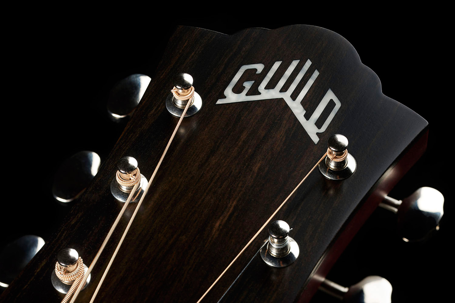 Close-up of front of the M-50 Standard Antique Burst headstock with Guild Peak logo