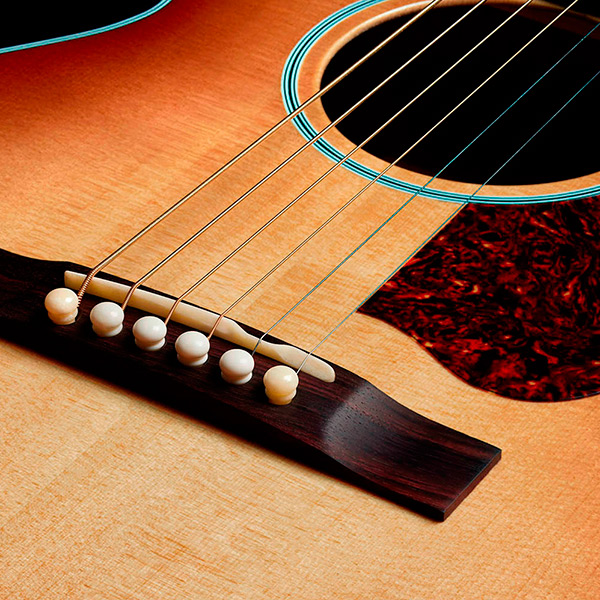 Close-up of the M-40 Standard Pacific Sunset Burst Indian rosewood bridge thumb