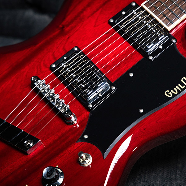 Close-up of the Polara Deluxe Cherry Red body featuring pickups and pickguard thumb