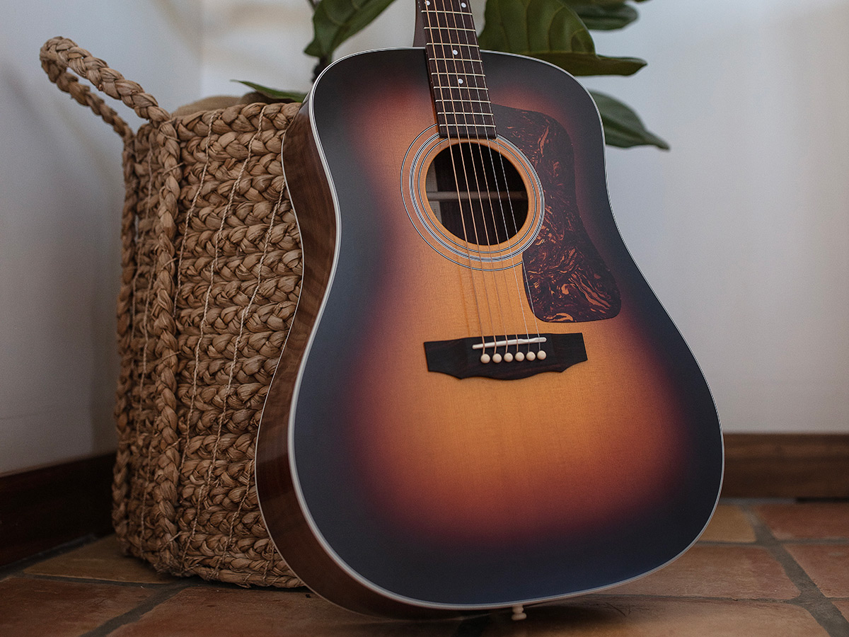 D-50 Standard Antique Burst leaning against a wicker pot with plant