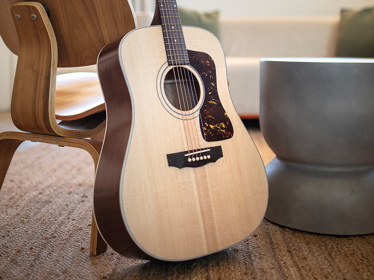 D-40 Standard Natural guitar leaning against a modern wood chair
