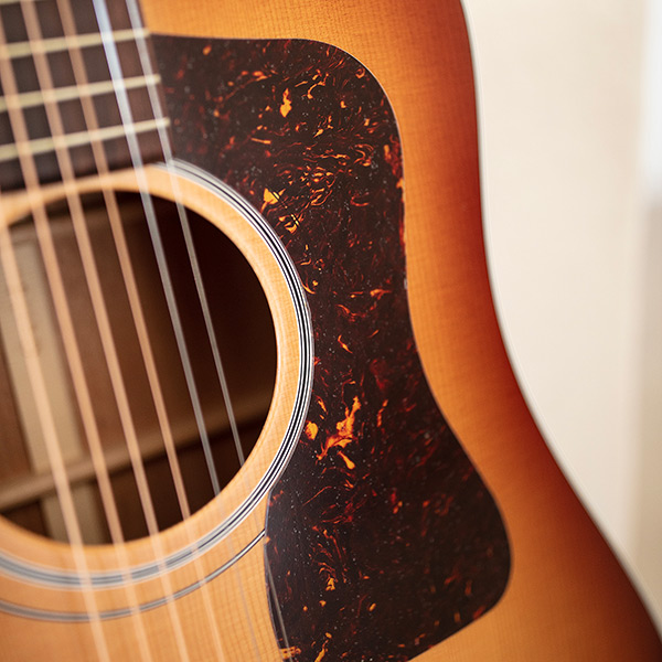 Close-up of D-40 Standard Pacific Sunset Burst pickguard thumb