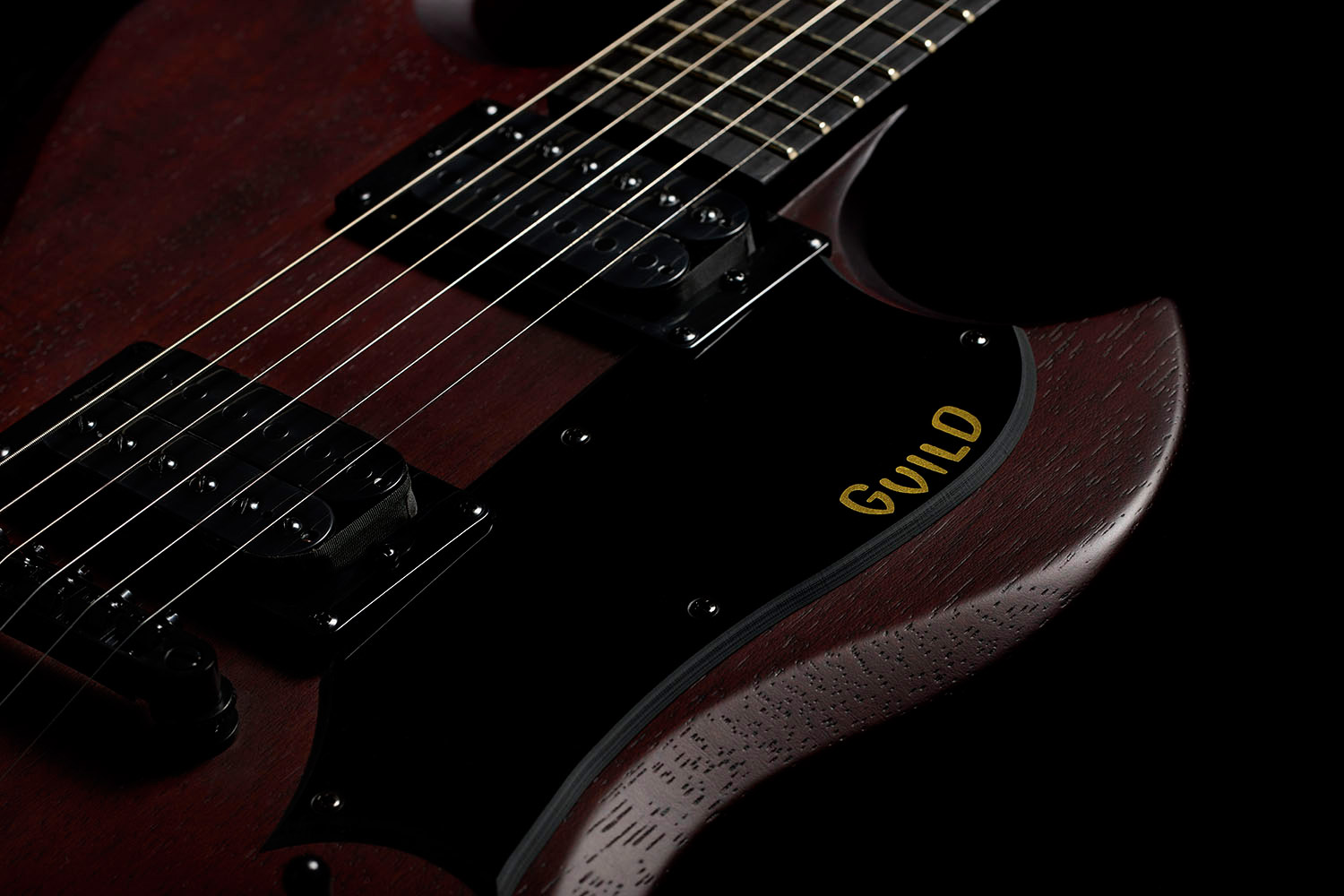 Close-up of Polara Limited Night Edition Vintage Walnut pick guard with Guild logo
