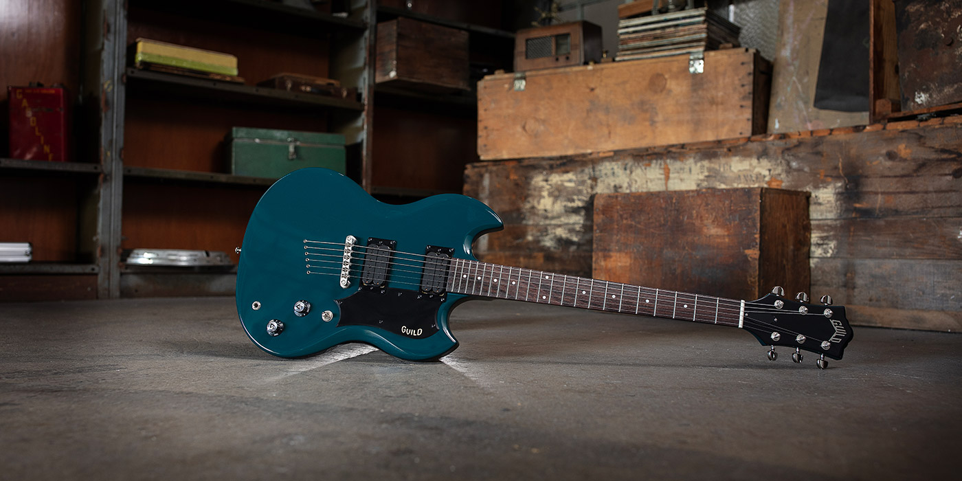 Blue Steel Polara leaning horizontal on concrete warehouse floor with wood boxes and metal shelves behind