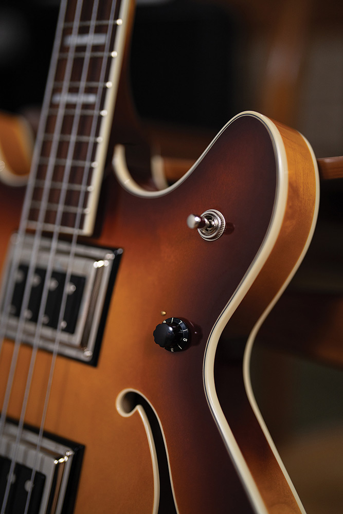 Close-up of the upper cutaway on a Starfire Deluxe Bass Sweet Tea, showing the pickup selector switch, control knob, and fingerboard inlay.