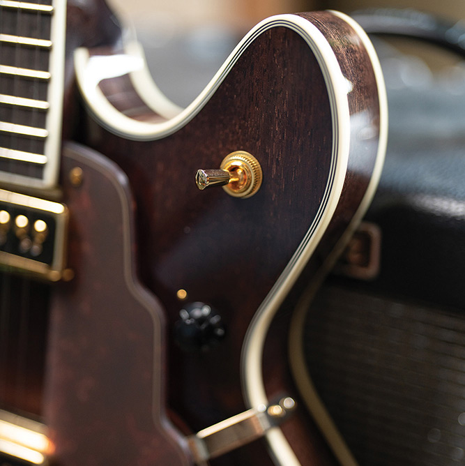 Close-up of the cutaway body edge on a Starfire Custom DC GVT GH, showing the gold output jack plate and ivory binding.