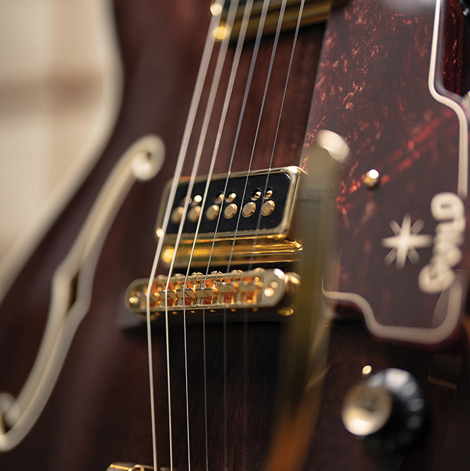 Close-up of a DeArmond Dynasonic pickup and tortoise pickguard on a Starfire Custom DC GVT GH, showing the printed Guild logo.