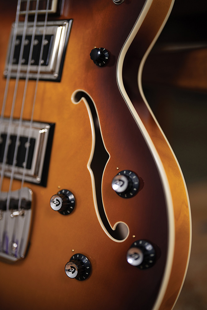 Close-up of the Starfire Deluxe Bass Sweet Tea showing the F-hole, control knobs, and ivory binding.