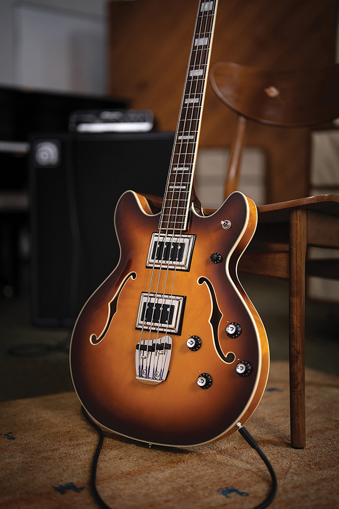 Angled full view of a Starfire Deluxe Bass Sweet Tea leaning on a chair, showing the double-cutaway body and pickups.