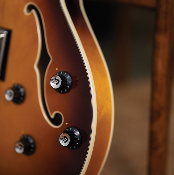Close-up of the lower body bout on a Starfire Deluxe Bass Sweet Tea, showing the F-hole, and control knobs.