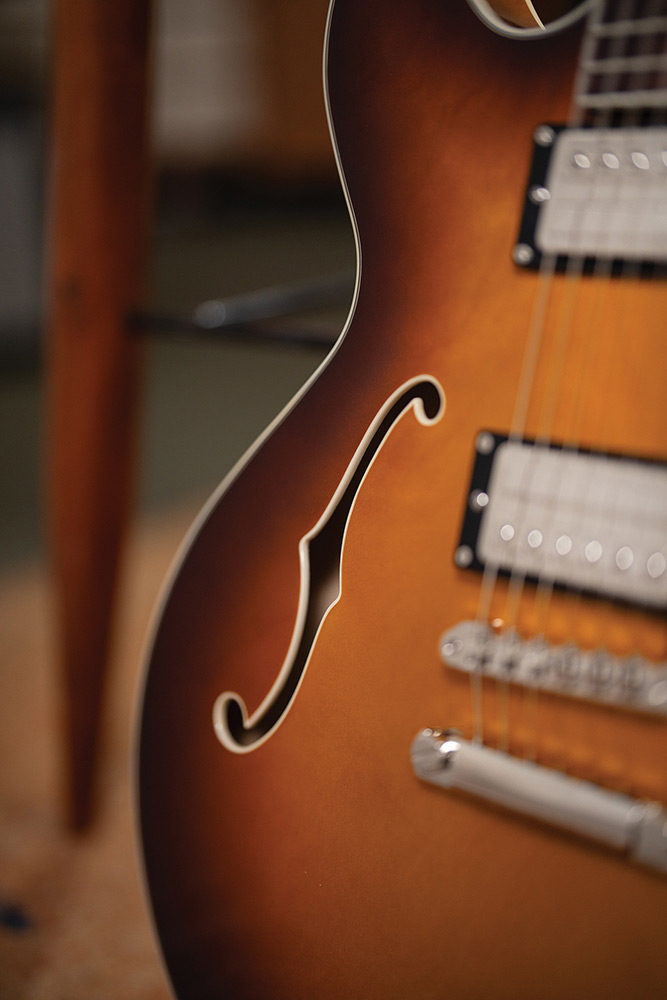 Close-up of the body bout on a Starfire Deluxe DC Sweet Tea, showing the F-hole, HB-2+ pickups, and Tune-o-matic bridge with stop tailpiece.