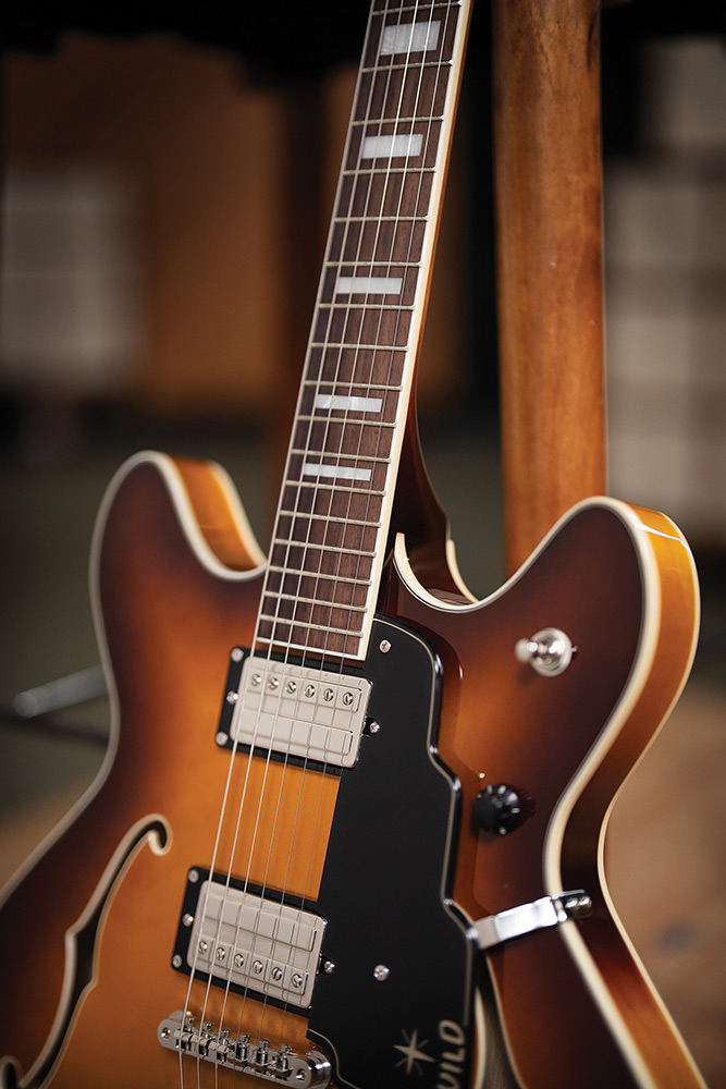 Close-up of the fingerboard and a pickup on a Starfire Deluxe DC Sweet Tea, showing the pearloid block inlays and ivory binding.