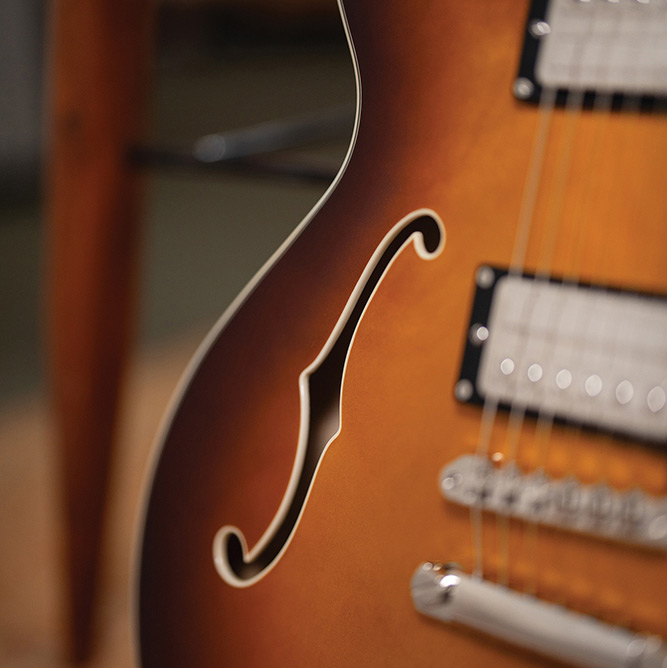Close-up of the body bout on a Starfire Deluxe DC Sweet Tea, showing the F-hole, HB-2+ pickups, and Tune-o-matic bridge with stop tailpiece.