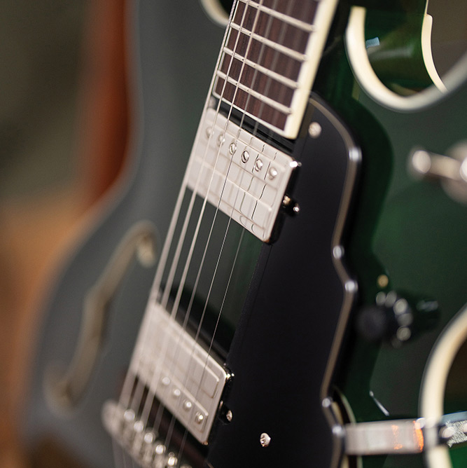 Close-up of the fingerboard and a pickup on a Starfire Deluxe DC GVT Emerald Green, showing the block inlays and F-hole.