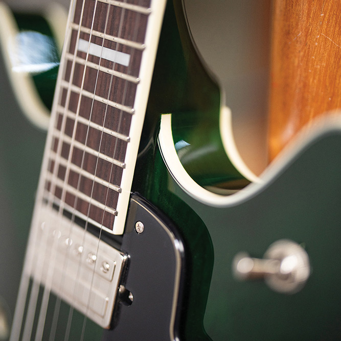 Close-up of the fingerboard and a pickup on a Starfire Deluxe DC GVT Emerald Green, showing the cutaway and ivory binding.
