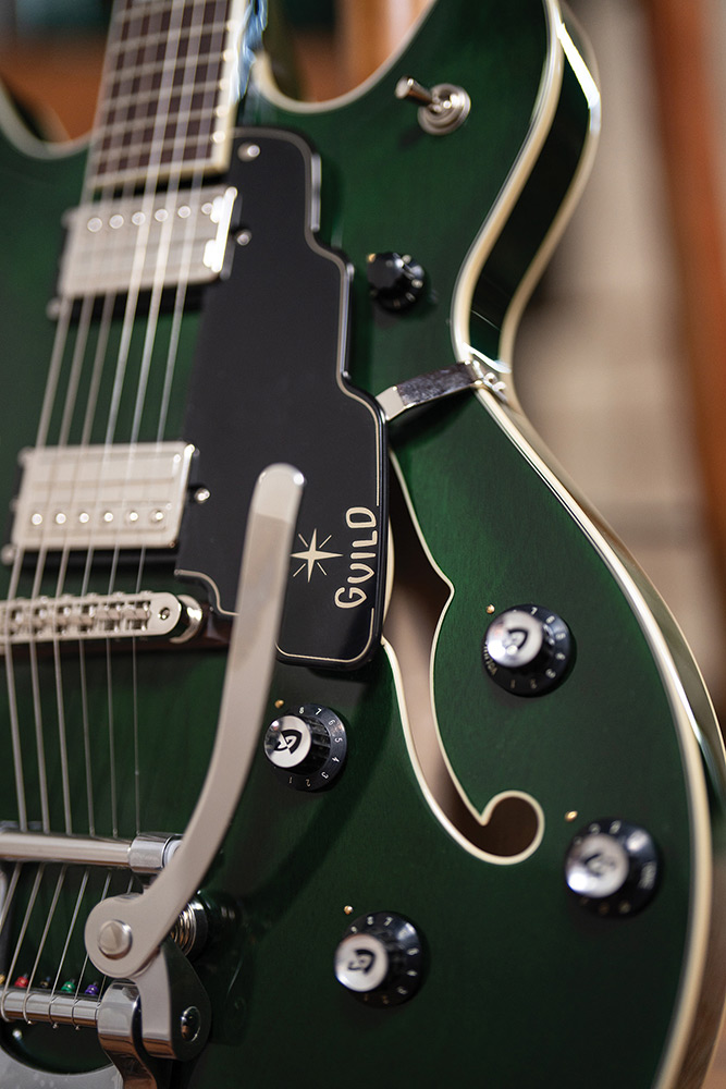 Close-up of the Starfire Deluxe DC GVT Emerald Green, showing the Guild Vibrato tailpiece, both HB-2+ pickups, and pickguard.