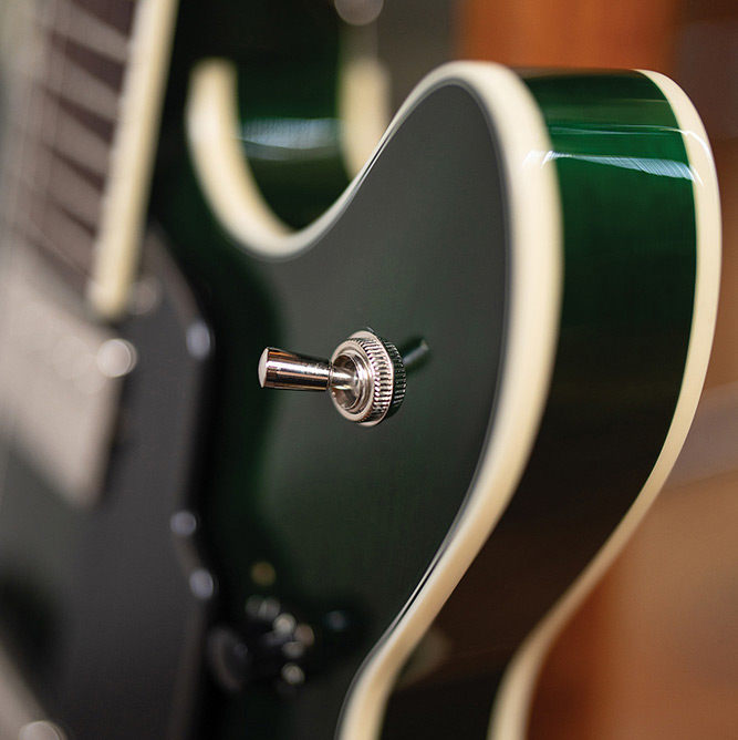 Close-up of the body edge and pickup selector switch on a Starfire Deluxe DC GVT Emerald Green, showing the ivory binding and Emerald Green finish.