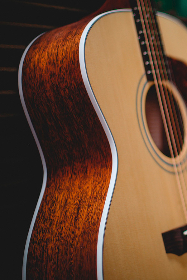 Close-up of F-40 acoustic guitar's body, showcasing its wood grain and smooth curves.