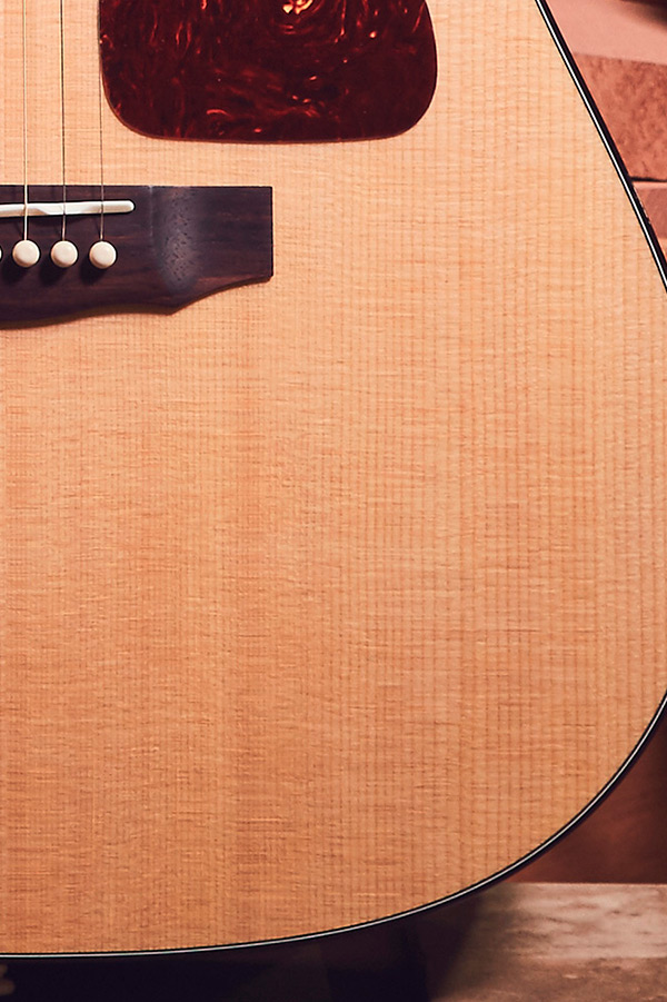 Close-up of D-40 acoustic guitar's body, showcasing the wood grain, bridge, and pickguard.