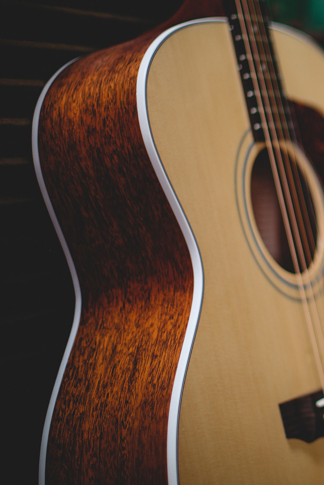 Close-up of F-40 acoustic guitar's body, showcasing its wood grain and smooth curves.