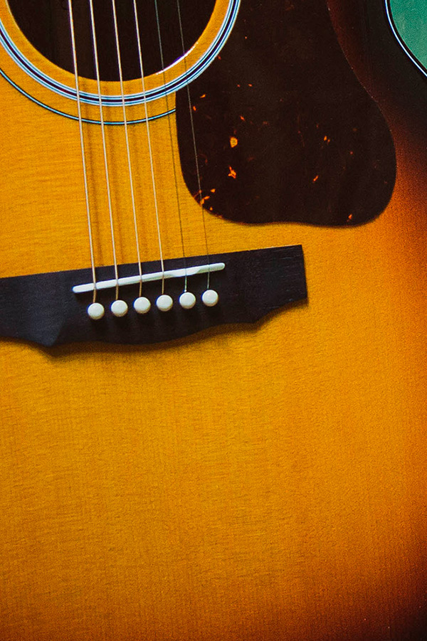Close-up of F-40 acoustic guitar's body, showcasing the strings, bridge, and a warm, antique burst finish.