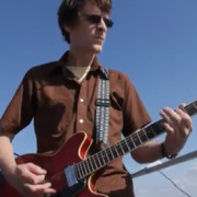 Steve Turner jouant de la guitare lors d'un spectacle